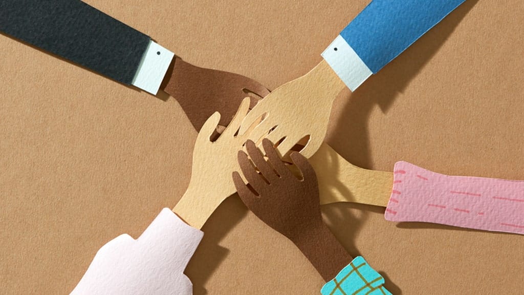 a group of people putting their hands together in a circle