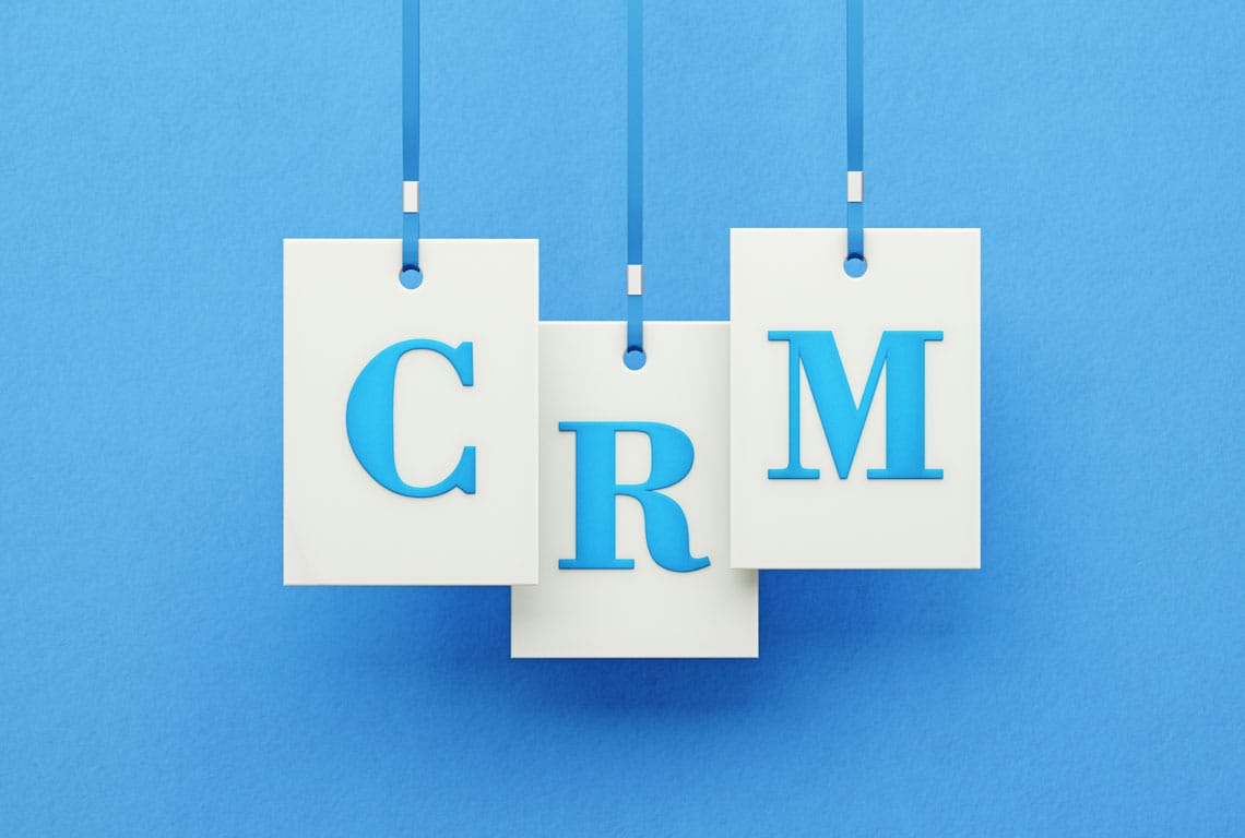 the word "CRM" with each letter on a white tag with a blue background